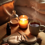 a softly lit bedside scene at night, bathed in warm amber and golden tones. a wooden nightstand holds a curated collection of cozy nighttime essentials.